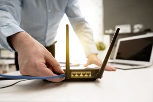 Man connects the internet cable to the router's socket