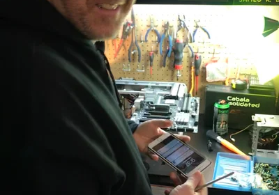 Man using phone to build computer